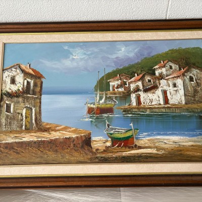 Quadro a óleo, com imagem de um lugar á beira mar, rodeado de casas e barcos