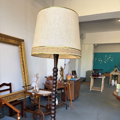 •	Candeeiro de pé, haste em madeira escura torneada e abajur cónico em tecido cru com acabamento dourado e uma faixa decorativa de inspiração clássica. 