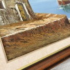Quadro a óleo, com imagem de um lugar á beira mar, rodeado de casas e barcos