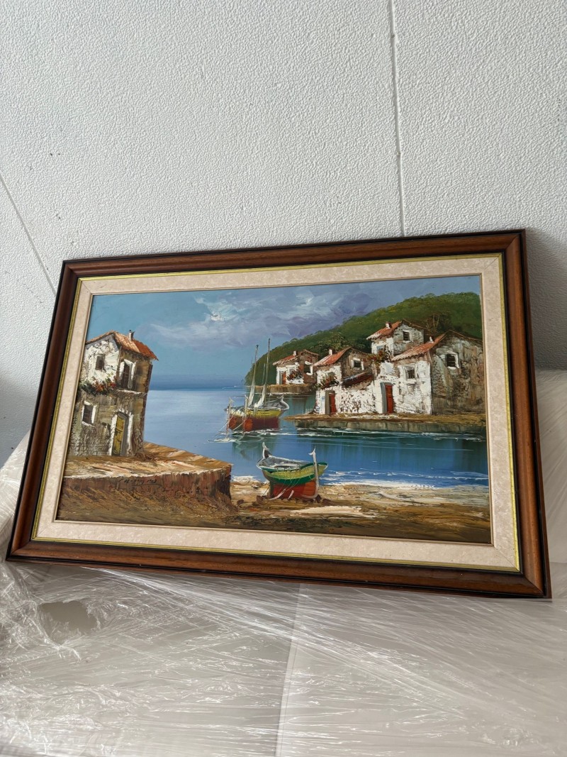 Quadro a óleo, com imagem de um lugar á beira mar, rodeado de casas e barcos