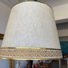 •	Candeeiro de pé, haste em madeira escura torneada e abajur cónico em tecido cru com acabamento dourado e uma faixa decorativa de inspiração clássica. 